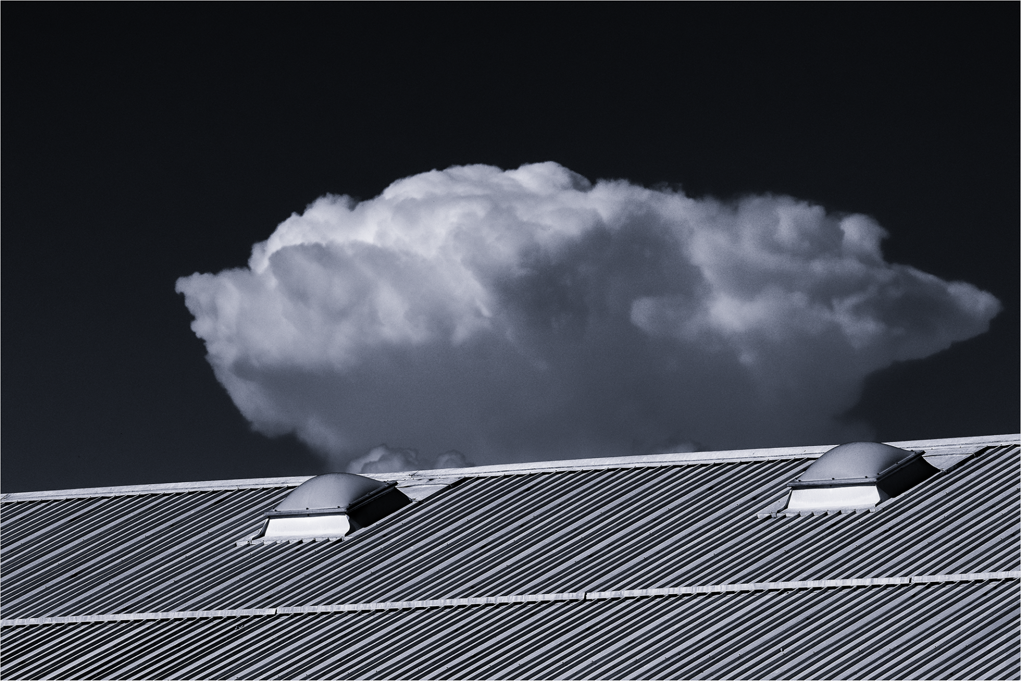 photographie toits entrepots avec gros nuage